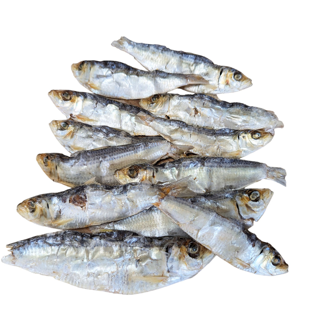 A pile of dried sprats on a white background. The sprats are silver in color and have a slightly wrinkled appearance.